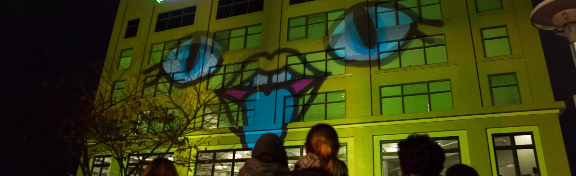 Motion design student work projected onto the side of a large building.
