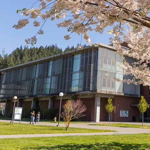 Academic West, which has a brick first floor with an overhanging second and third story both with floor to ceiling windows