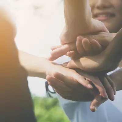 Close-up of several hands stacked on top of each other.