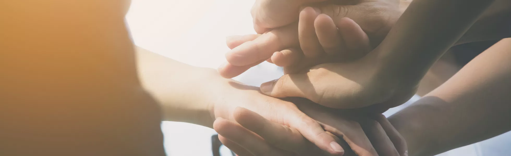 Close-up of several hands stacked on top of each other.