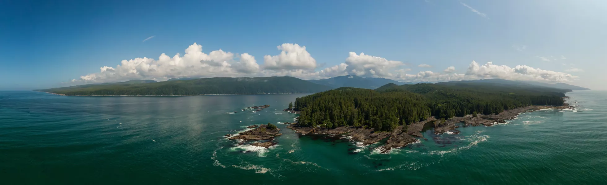 Coastal islands northwest of Vancouver, British Columbia. Lots of green trees on a bluff overlooking the sea.