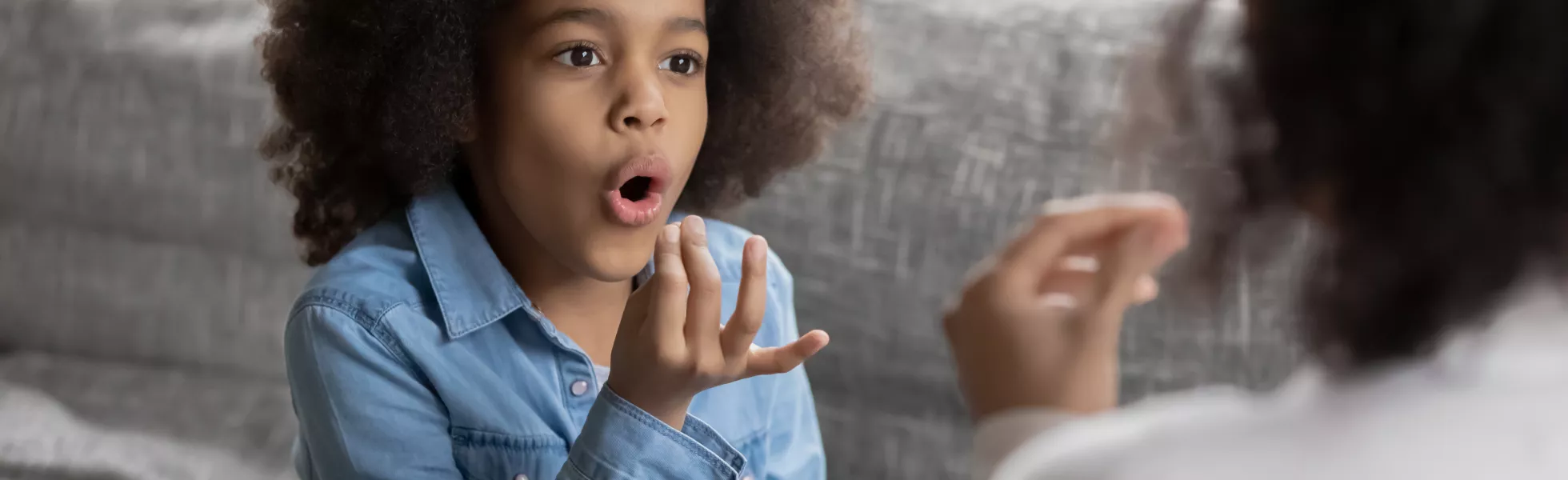 A child using gestures while talking with an adult.