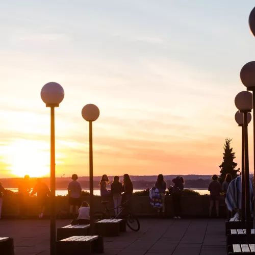 People watch the sunset from Western's PAC plaza.