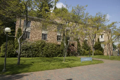 College Hall, a three story brick building with a terra-cotta roof.
