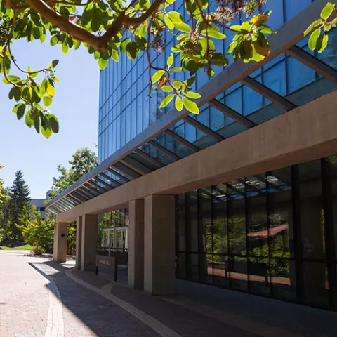 Morse Hall, a three story glass building with a glass awning in front.