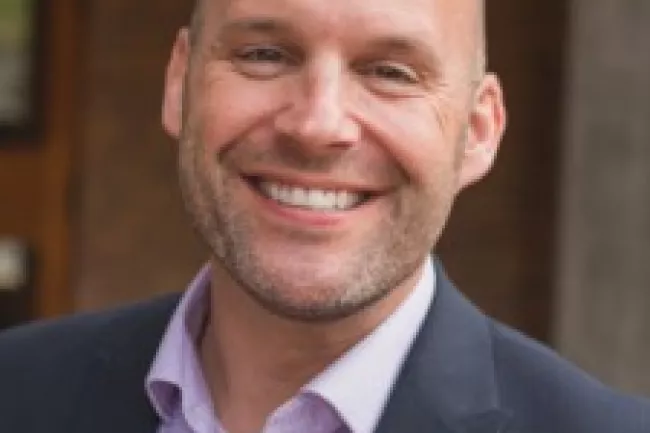 Chris Roselli smiling in a suit