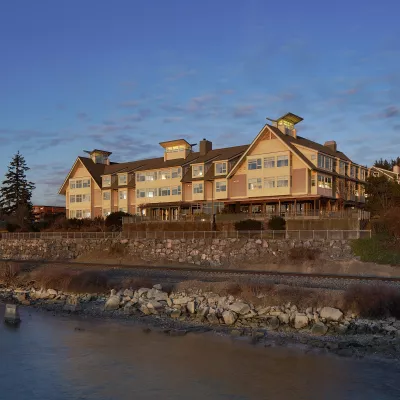 Rustic Hotel Chrysalis on the shore of Bellingham Bay with railroad tracks running below.