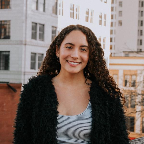 Mariana Urrea smiling in front of buildings.