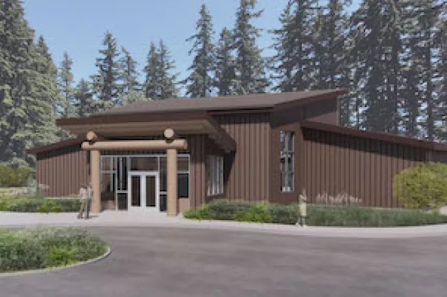 The House of Healing rendering showing the front of the building clad in brown siding with an archway made of logs at the front door