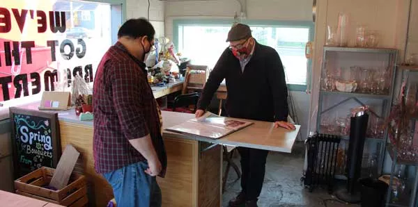 Two business people gather round an office desk reviewing a booklet.
