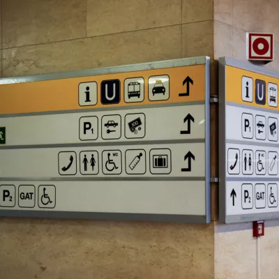 Multiple symbols on a sign on a pillar in a German airport.
