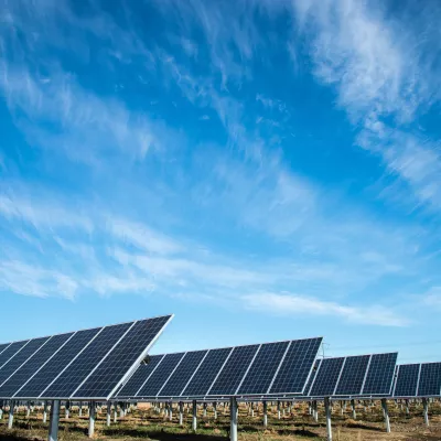 Solar panels against a lightly cloudy blue sky