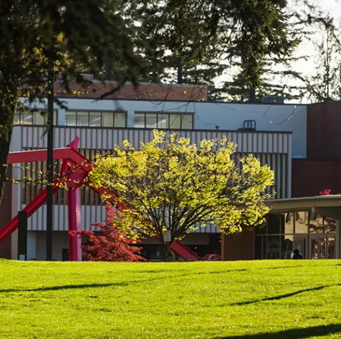 The Performing Arts Center sits behind a large, angular red sculpture.