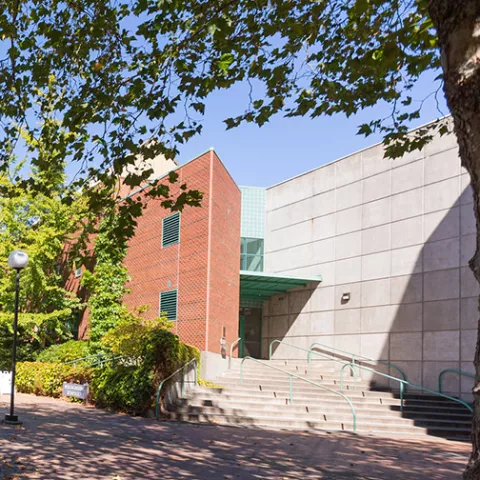 Ross Engineering, a two-story concrete and brick building lined with ivy and trees.
