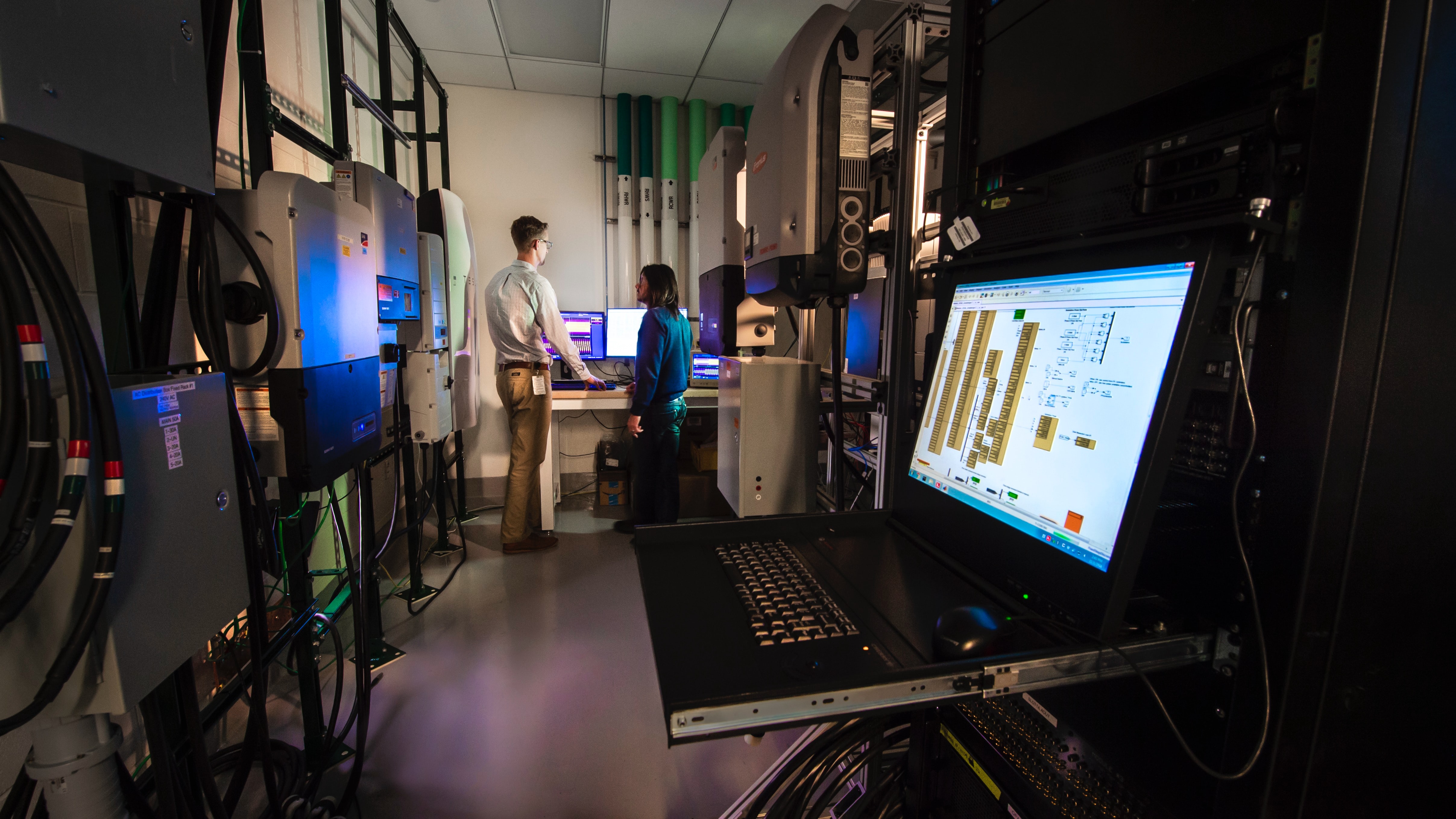 professor and student in a computer science lab with laptop in foreground