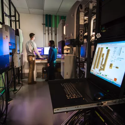 professor and student in a computer science lab with laptop in foreground