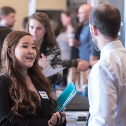 A large room of people in professional attire networking.