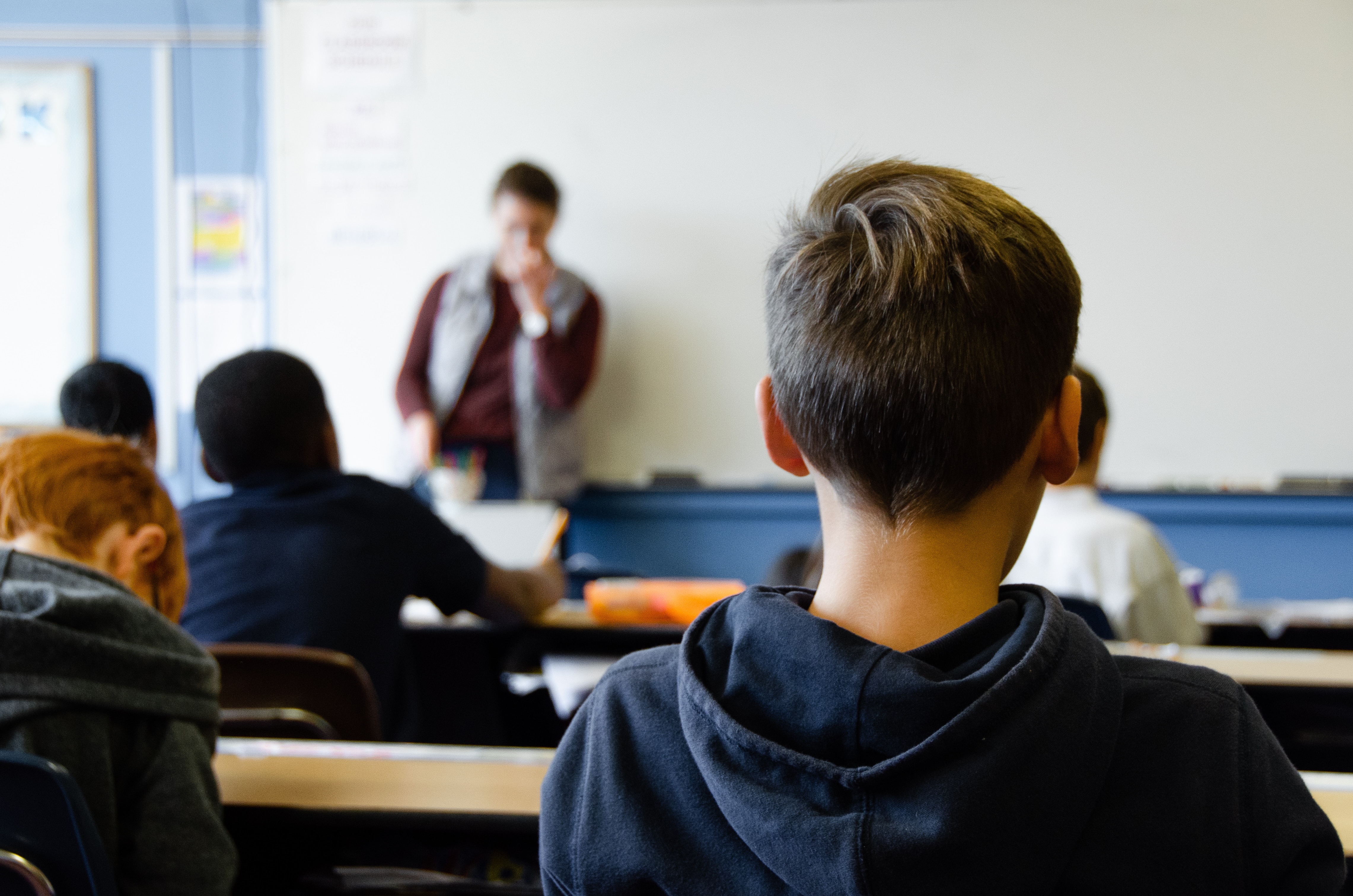 A teacher at the whiteboard in front of a classroom of students