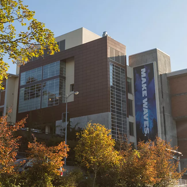 Viking Union, a brick and glass building on a hillside with a large banner reading "Make Waves" running down the side.