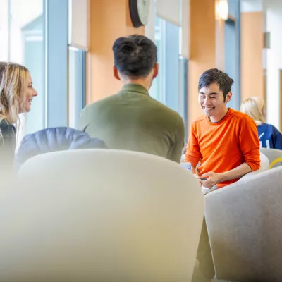 Four students sitting in a circle, having a discussion.