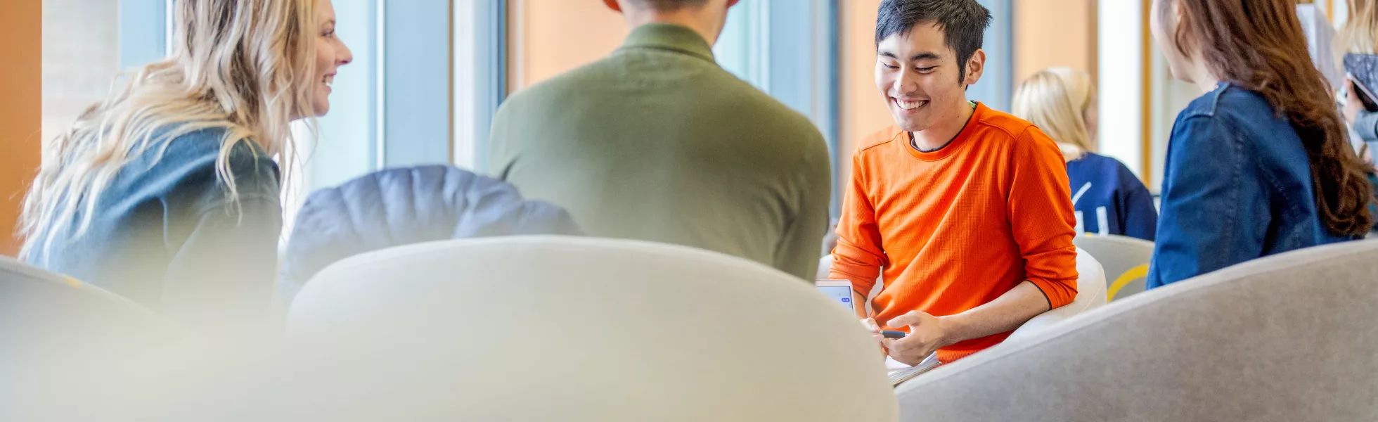 Four students sitting in a circle, having a discussion.