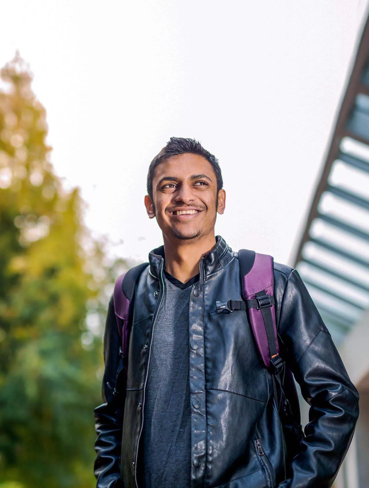 Student Amir Shahzad smiles in front of a building at Western