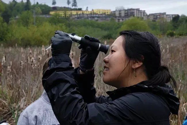 A person peering through a telescope